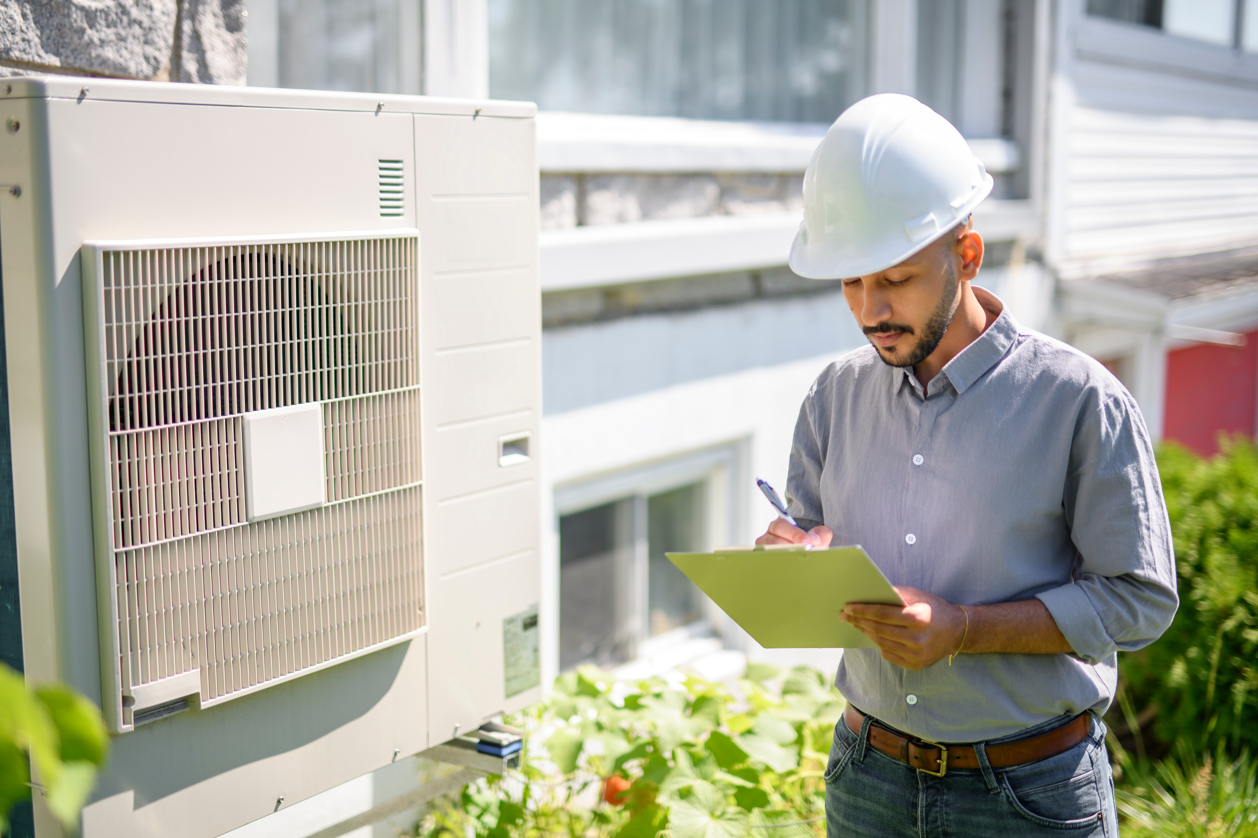 Man-with-hard-hat-Heat-pump-inspect